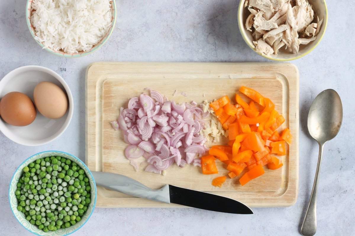 Chopped shallots, garlic and pepper on chopping board.