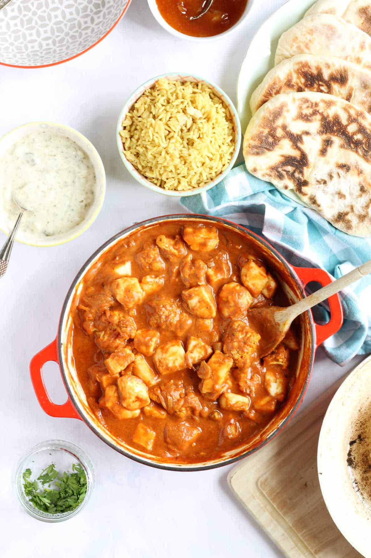 Overhead photo of a curry night feast with vegetarian curry, pilau rice and homemade naan bread.