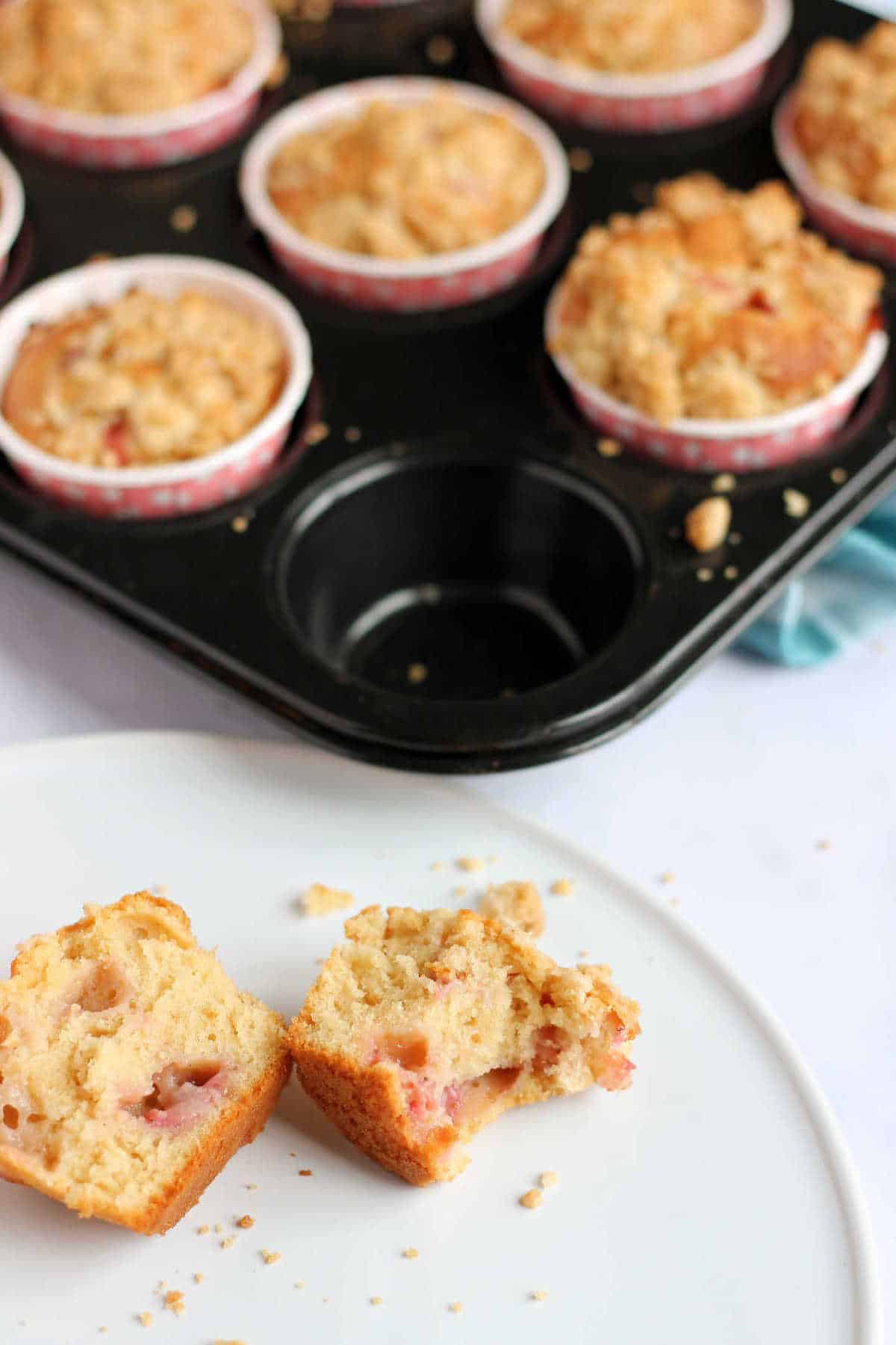 A strawberry muffin cut in half on a plate.