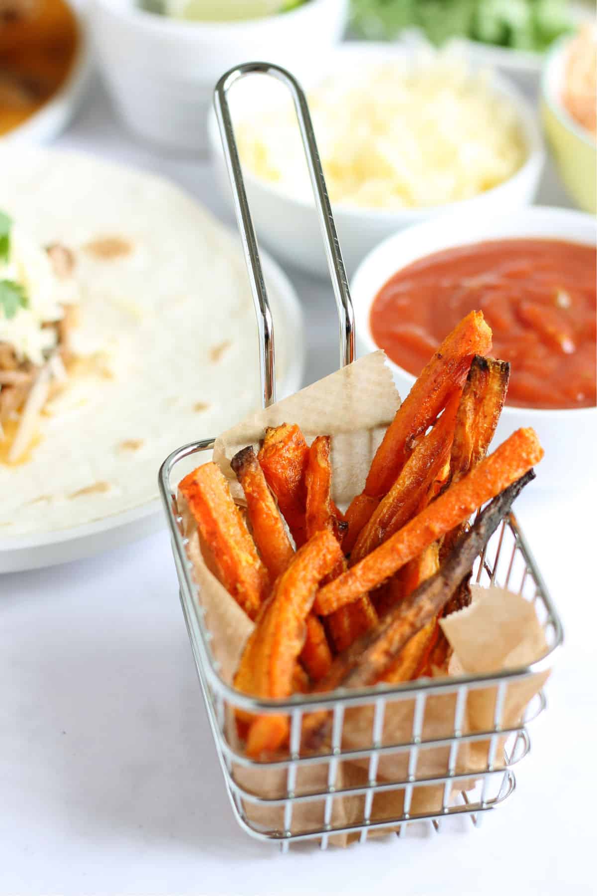 A portion of baked carrot fries with homemade ketchup