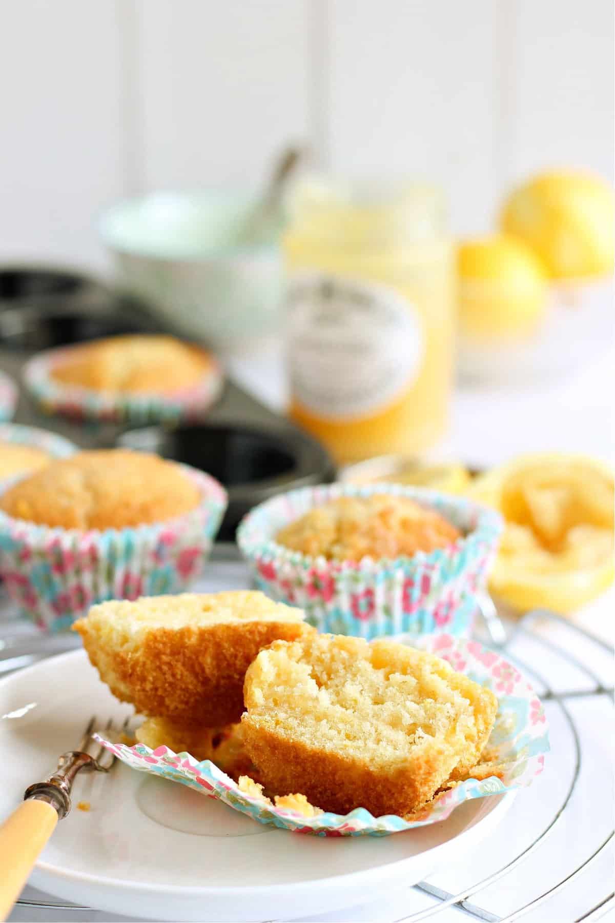 A lemon drizzle muffin cut in half on a plate.