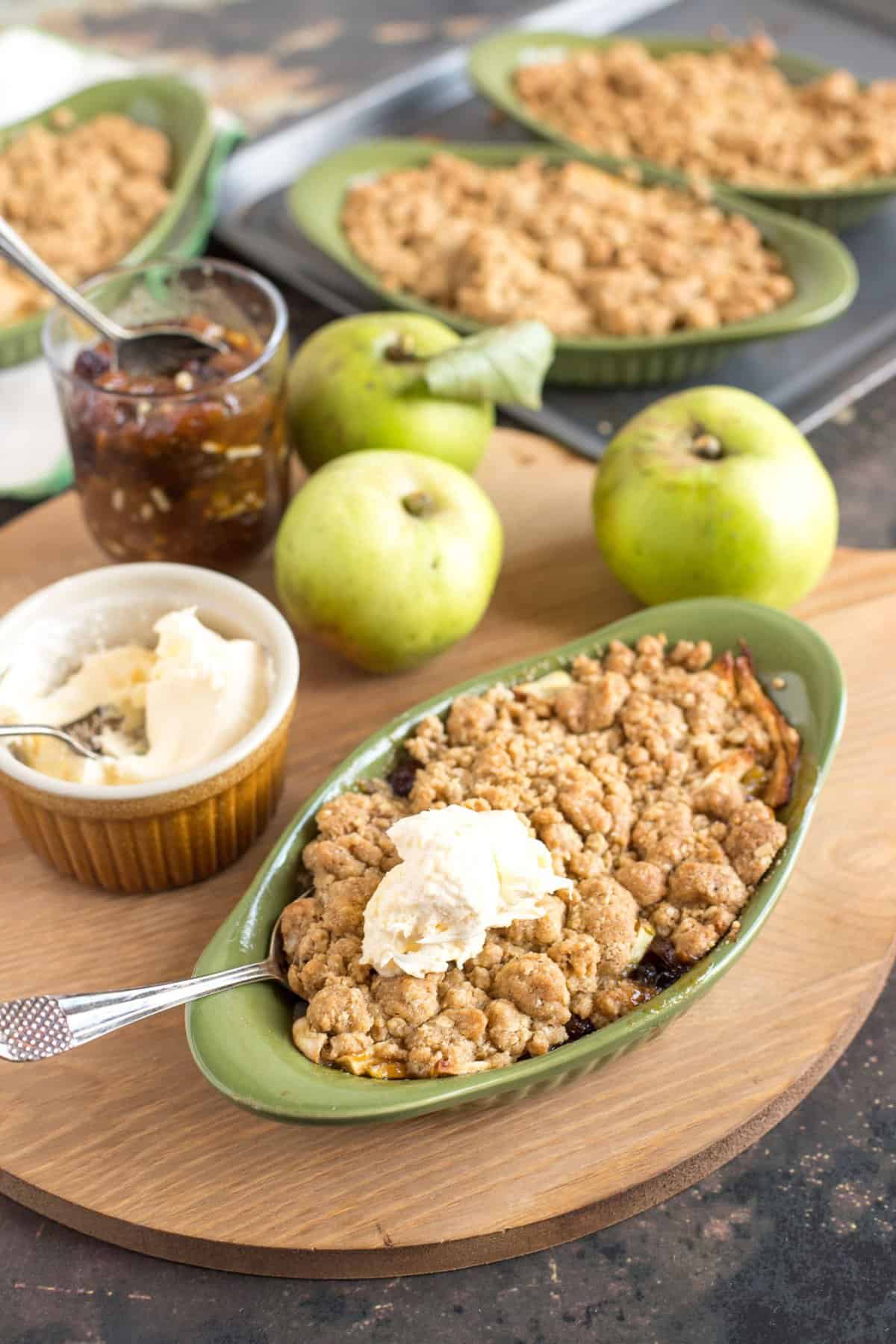 An individual serving of Apple and Mincemeat Crumble with clotted cream on top.