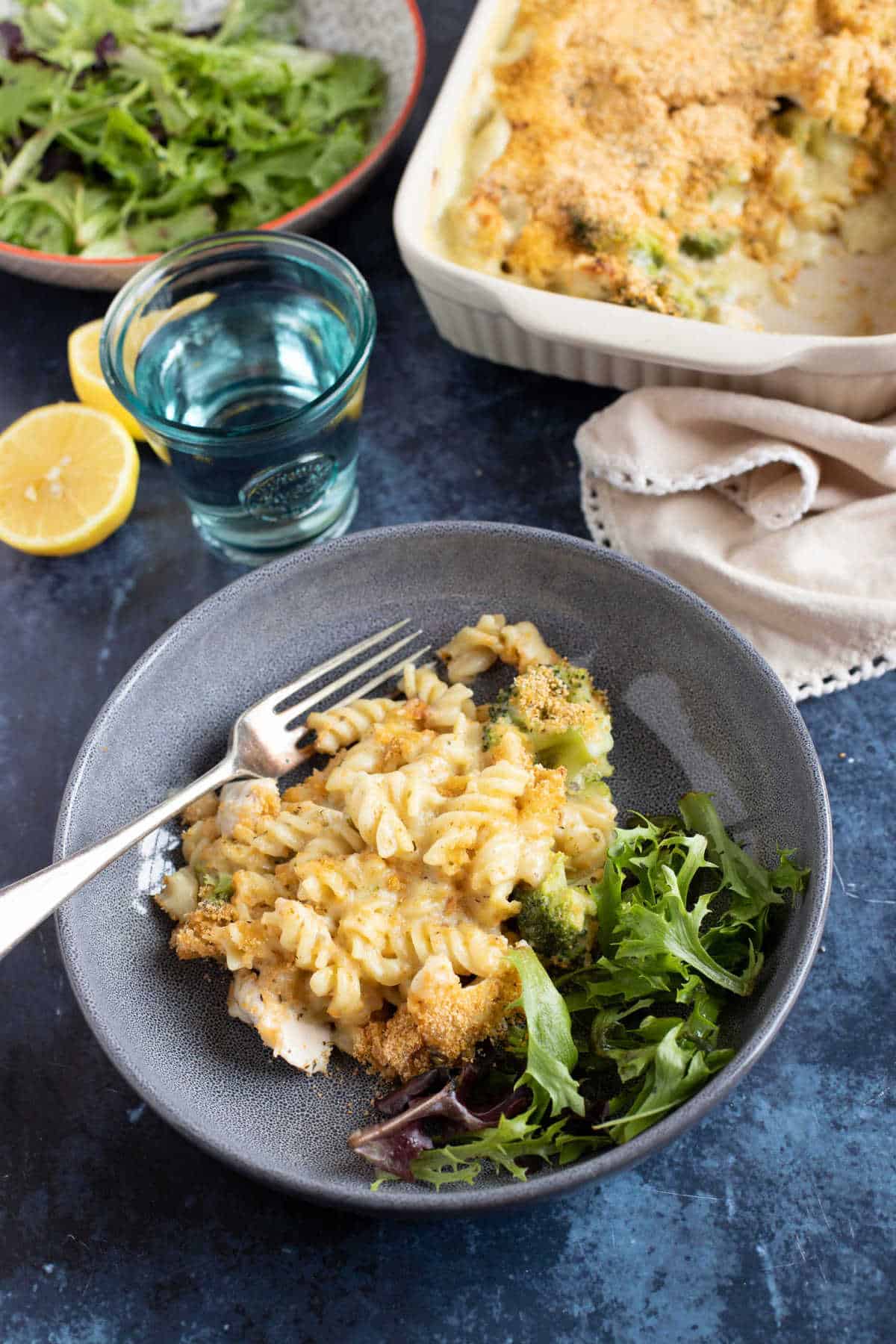 A bowl of chicken pasta bake with green salad.