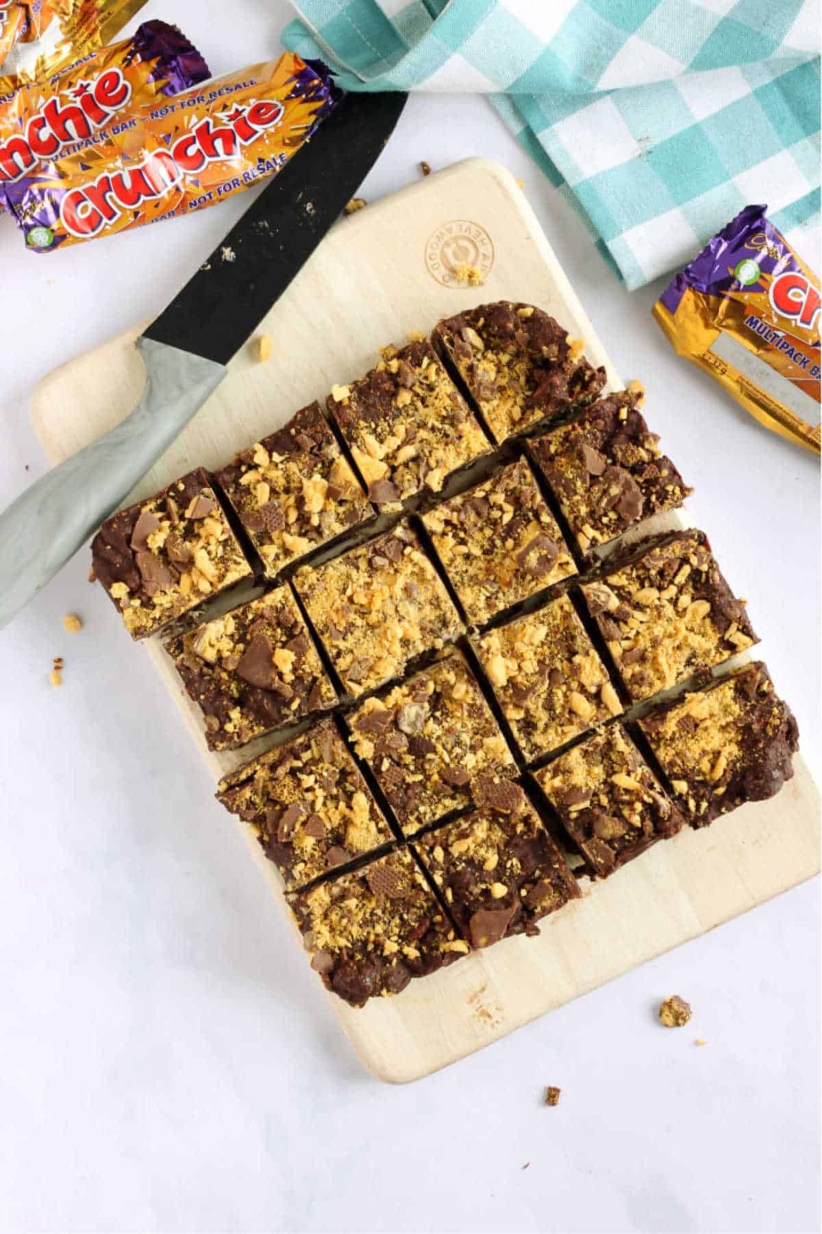 Overhead shot of chocolate crunchie tiffin, cut into squares with a grey knife.