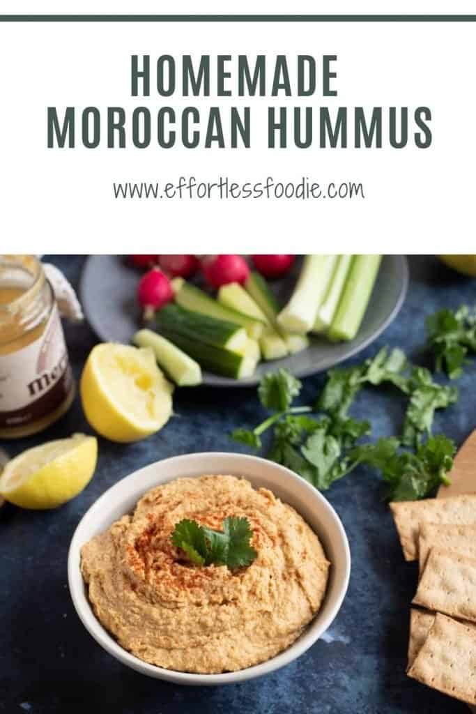 Homemade Hummus in a bowl with raw vegetables Pinterest Pin with text overlay.