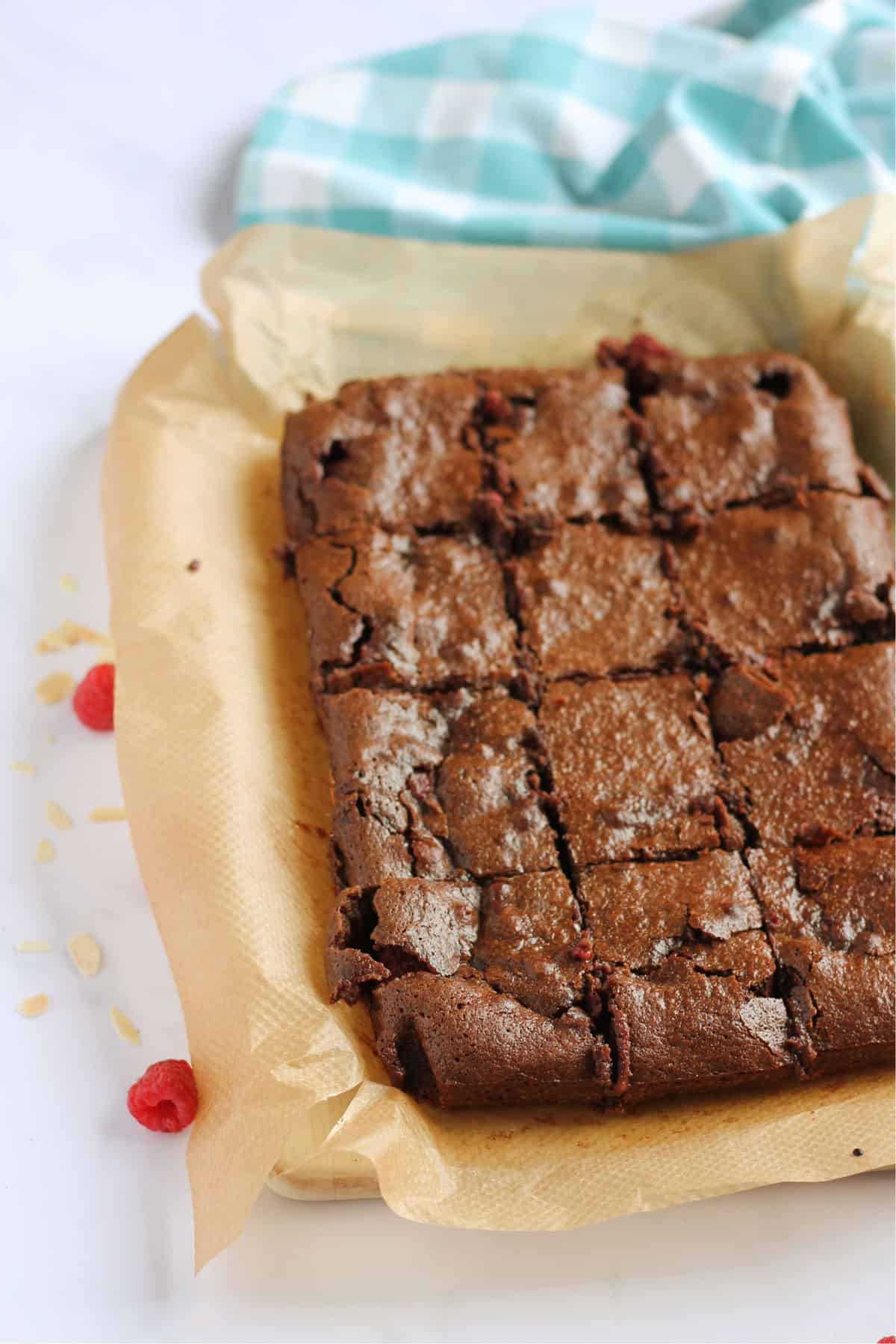 A tray of dark chocolate raspberry brownies cut into squares.