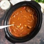 Slow cooker beef goulash in a black slow cooker basin.