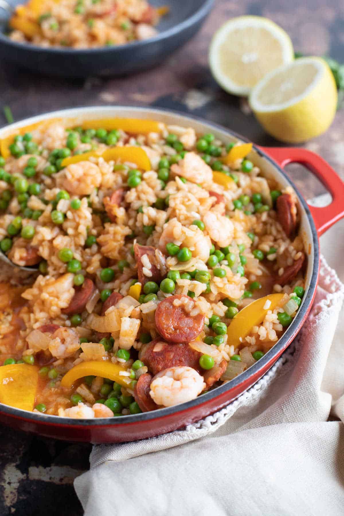 Paella with lemon wedges in the background.