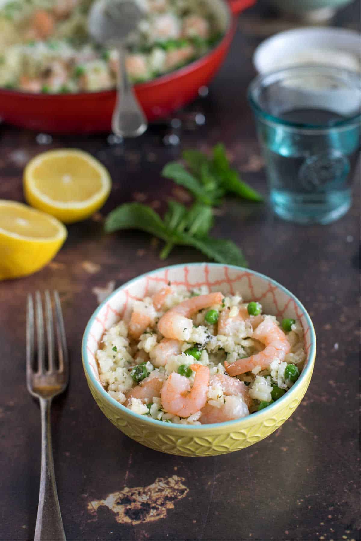 A bowl of prawn and pea risotto with lemon.