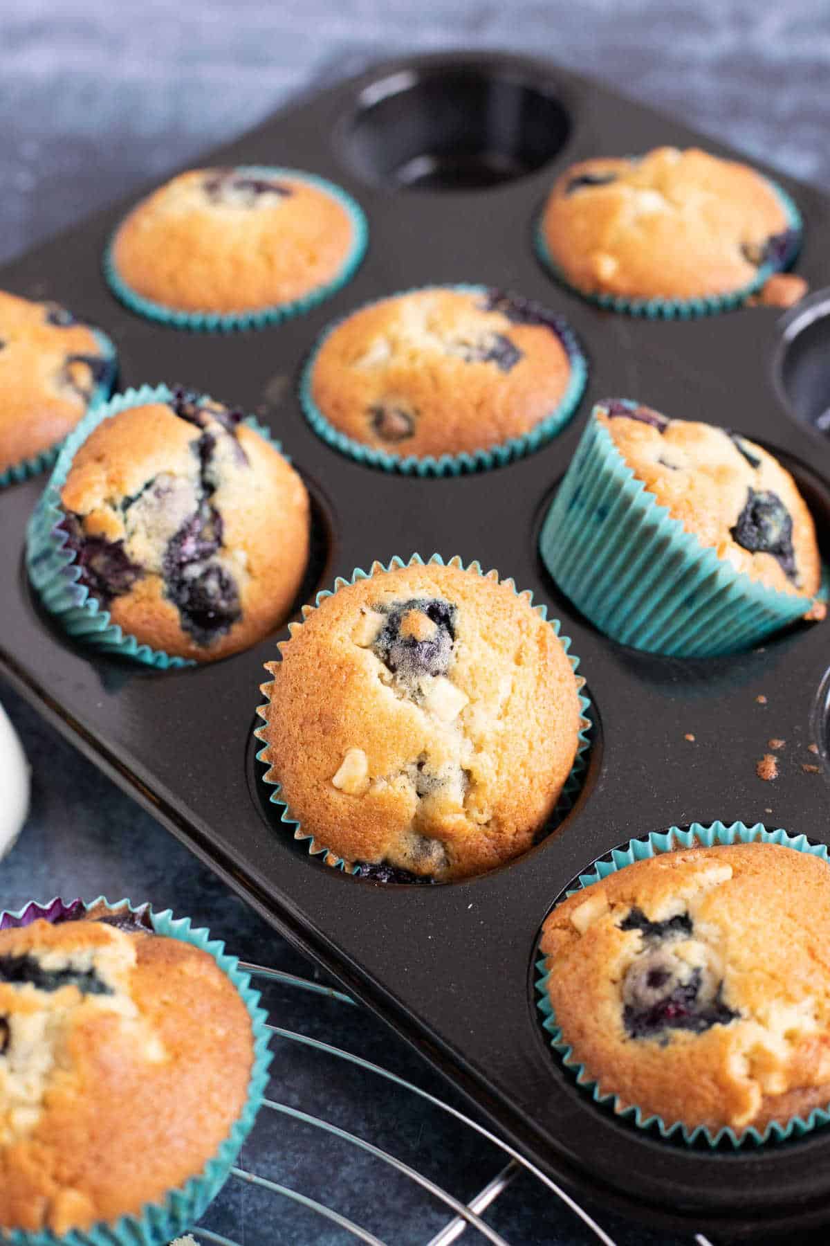 A tray of blueberry muffins with white chocolate chips.