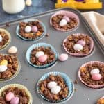 Chocolate cornflake cakes in a muffin pan with mini eggs.