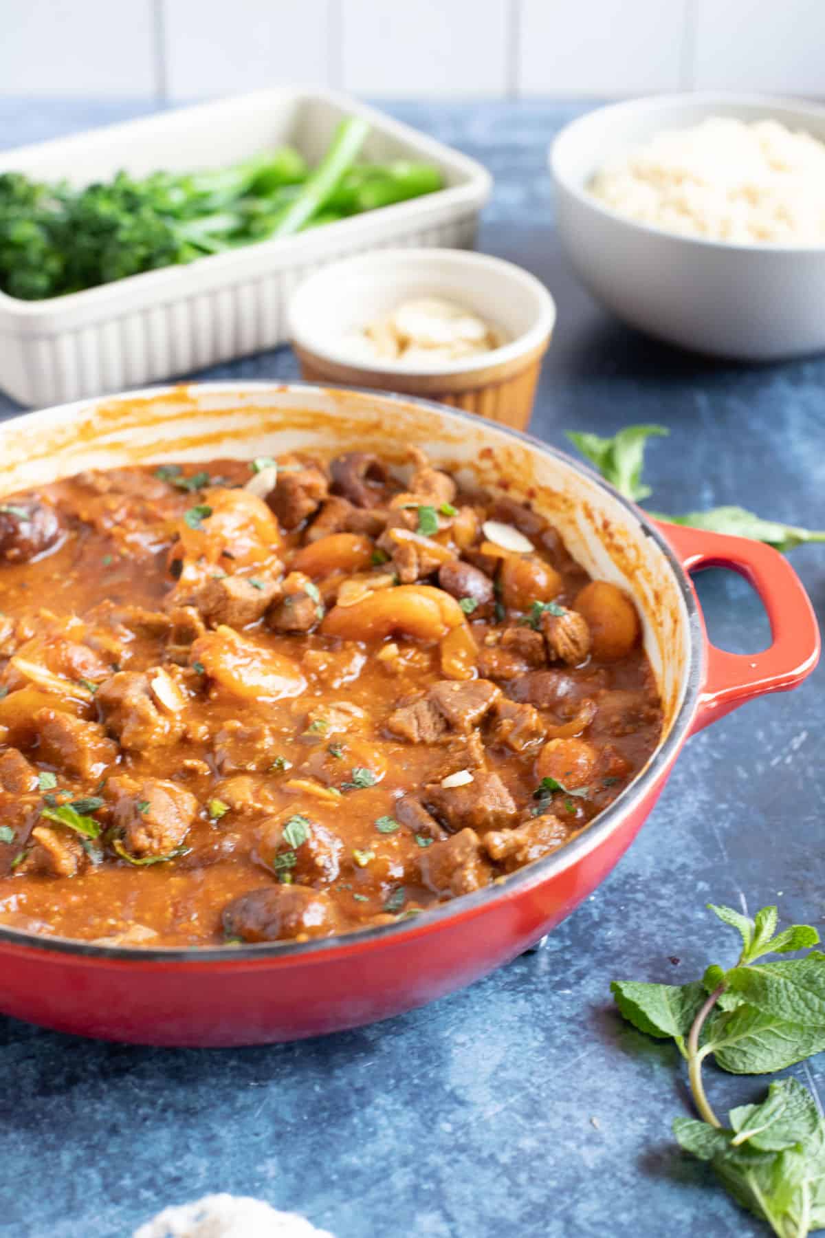 Lamb tagine with apricots in a red pan.