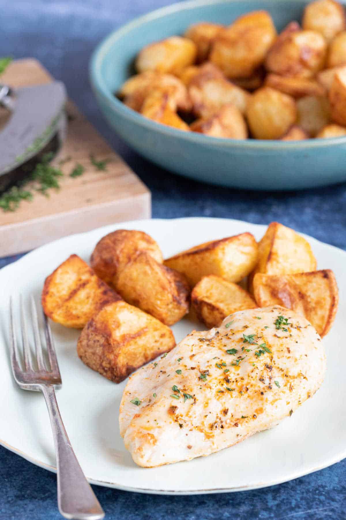 Air fryer Italian chicken breast served with air fryer roast potatoes.