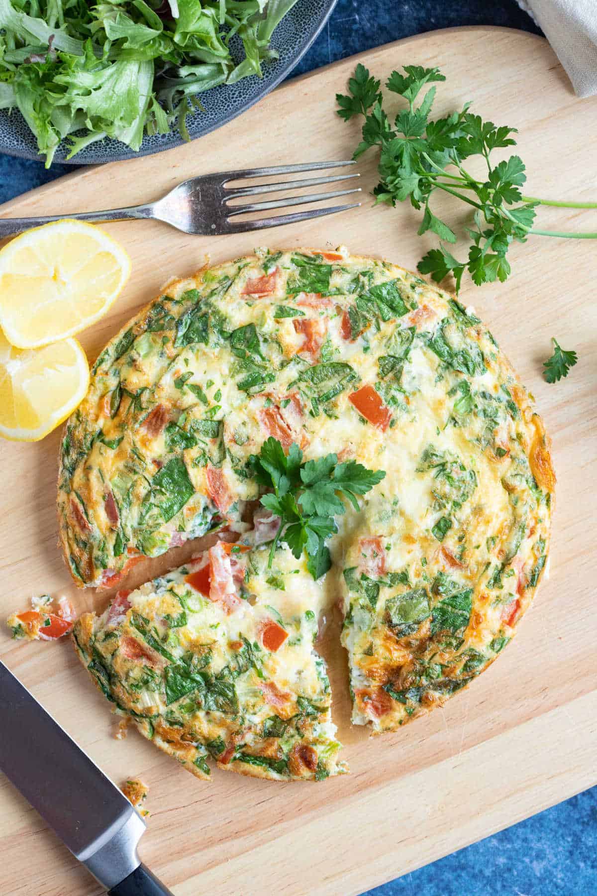 Sliced air fryer breakfast frittata with tomatoes and spinach.