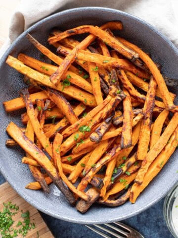 A bowl of seasoned air fryer sweet potato fries.