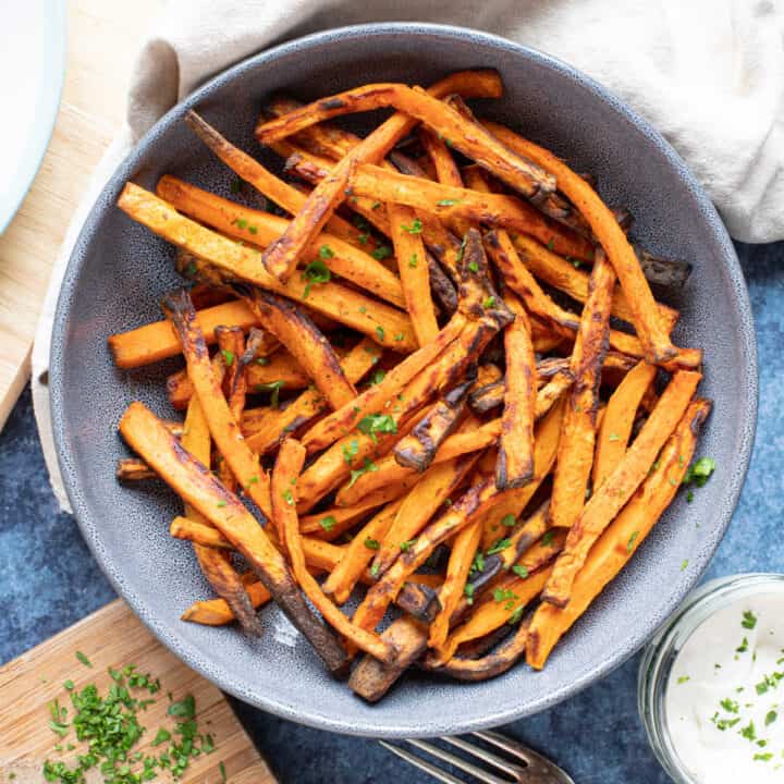 A bowl of seasoned air fryer sweet potato fries.