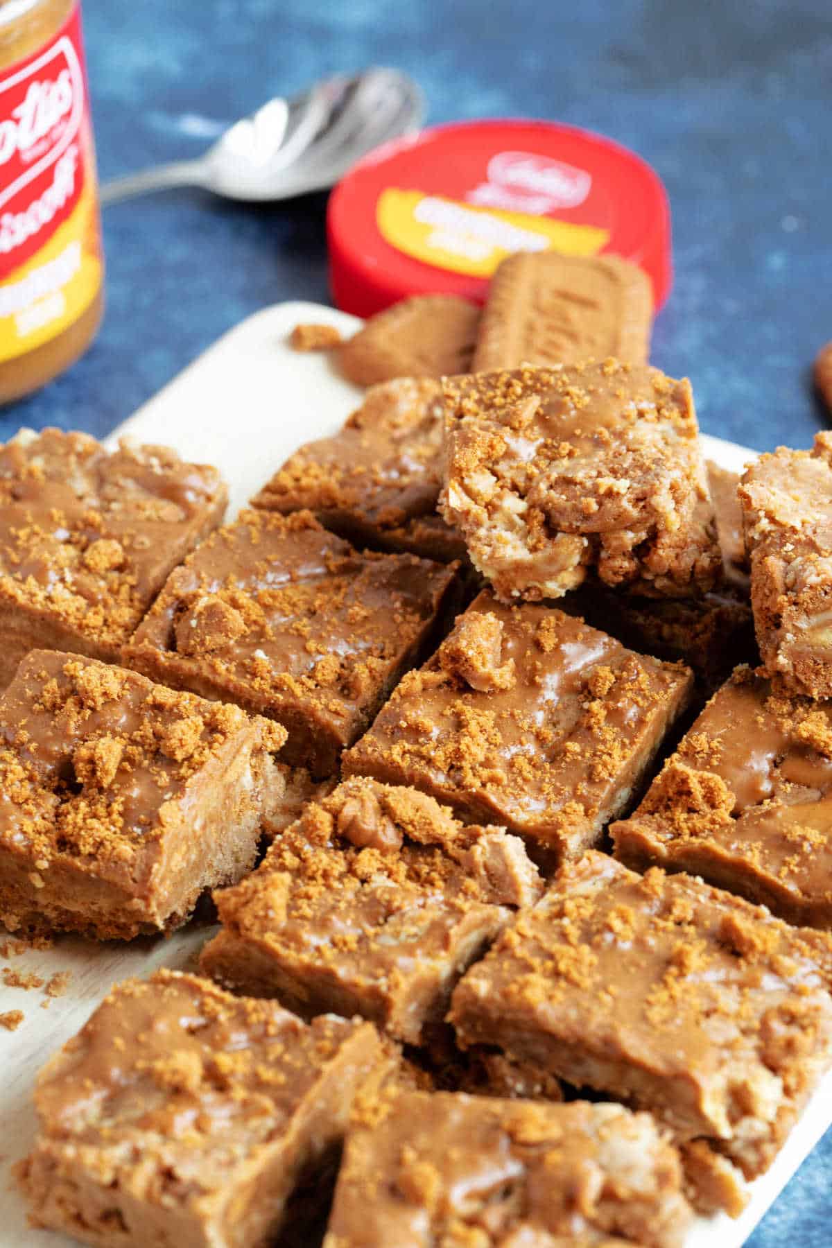 Biscoff tiffin bars with a jar of Biscoff spread in the background.