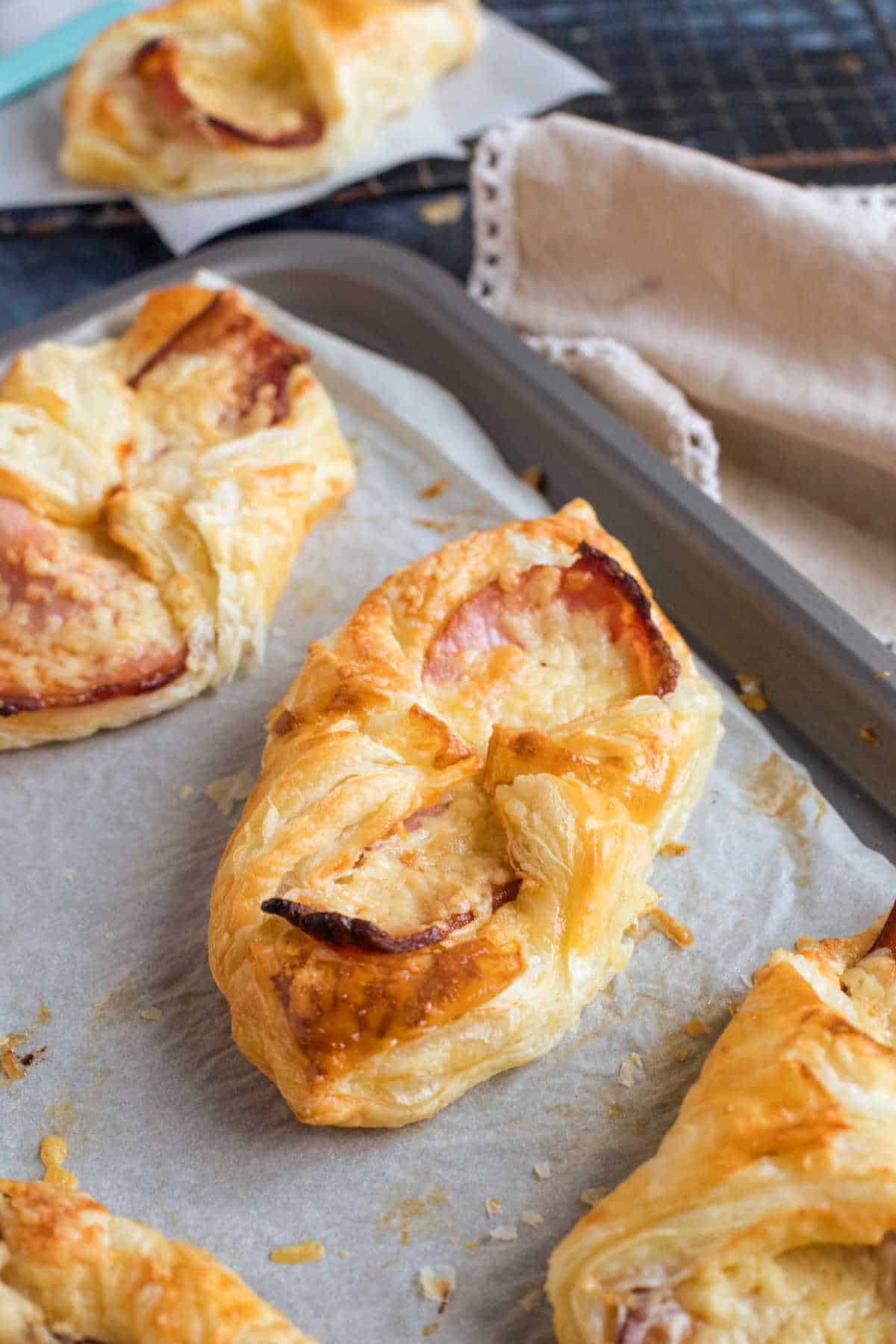 Fatturati di formaggio e pancetta (copycat Greggs) su una teglia da forno.