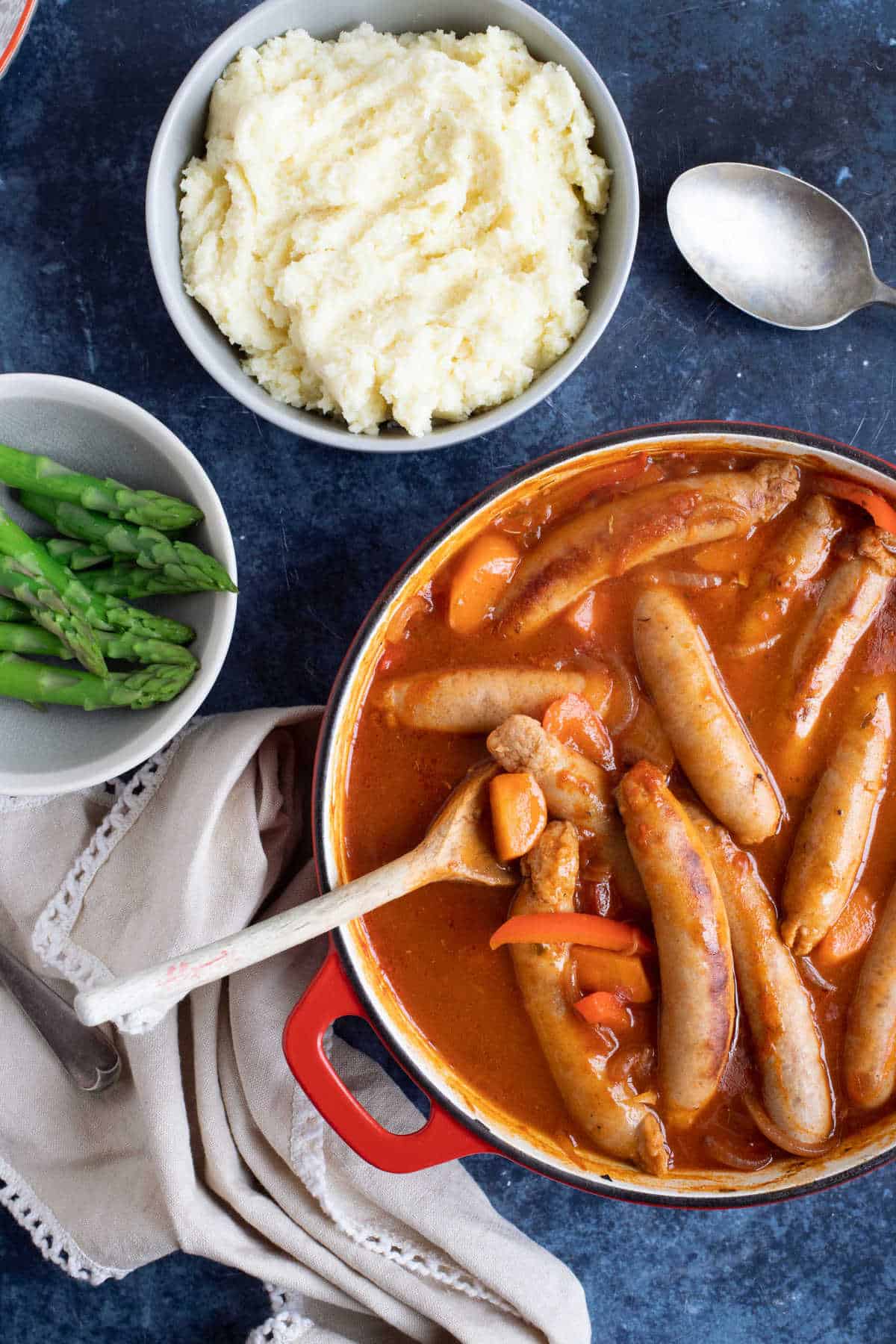 Sausage casserole with mashed potato and asparagus.