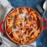 halloumi pasta with smoky chorizo in a red dish.