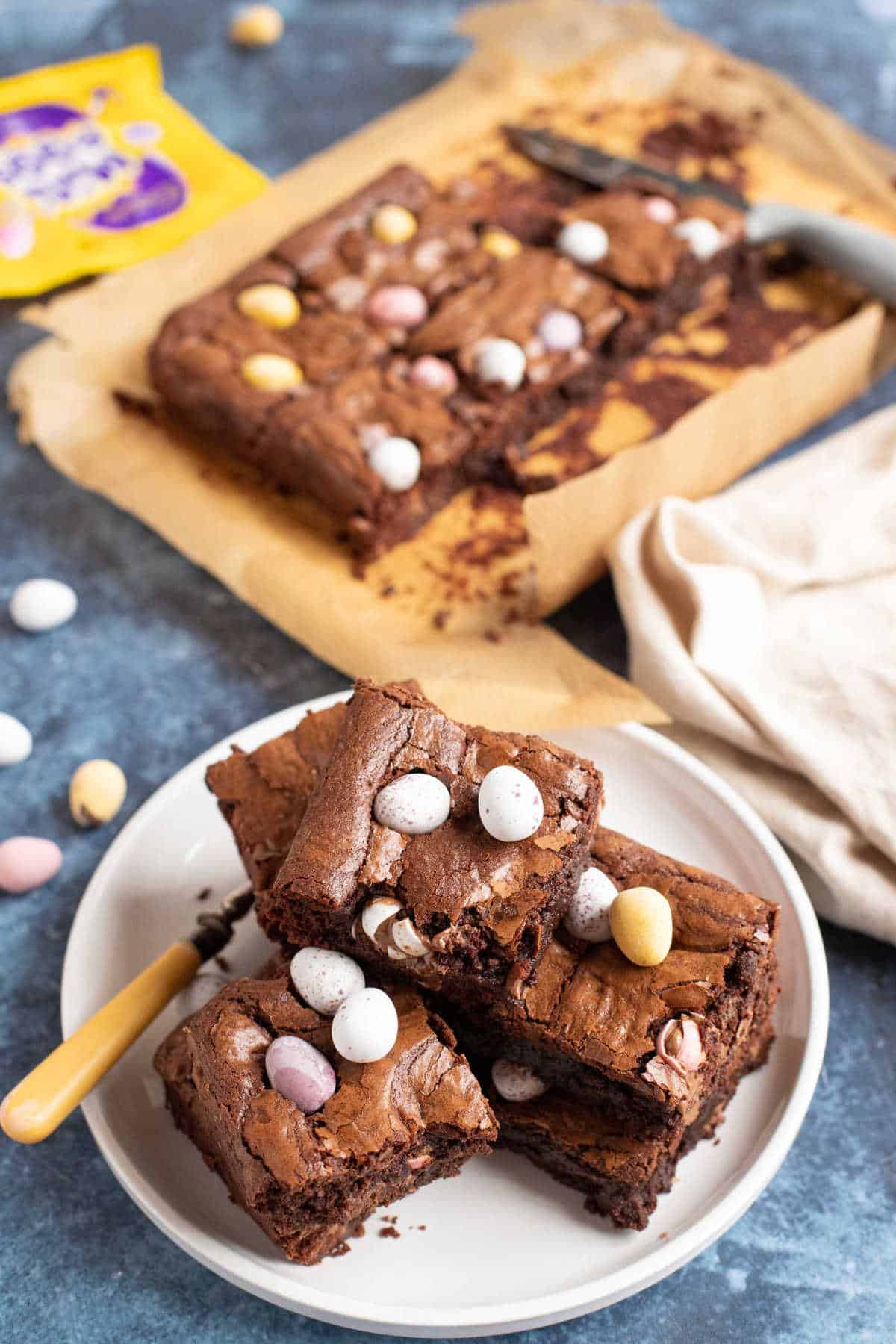 Mini egg brownies stacked on a white plate.