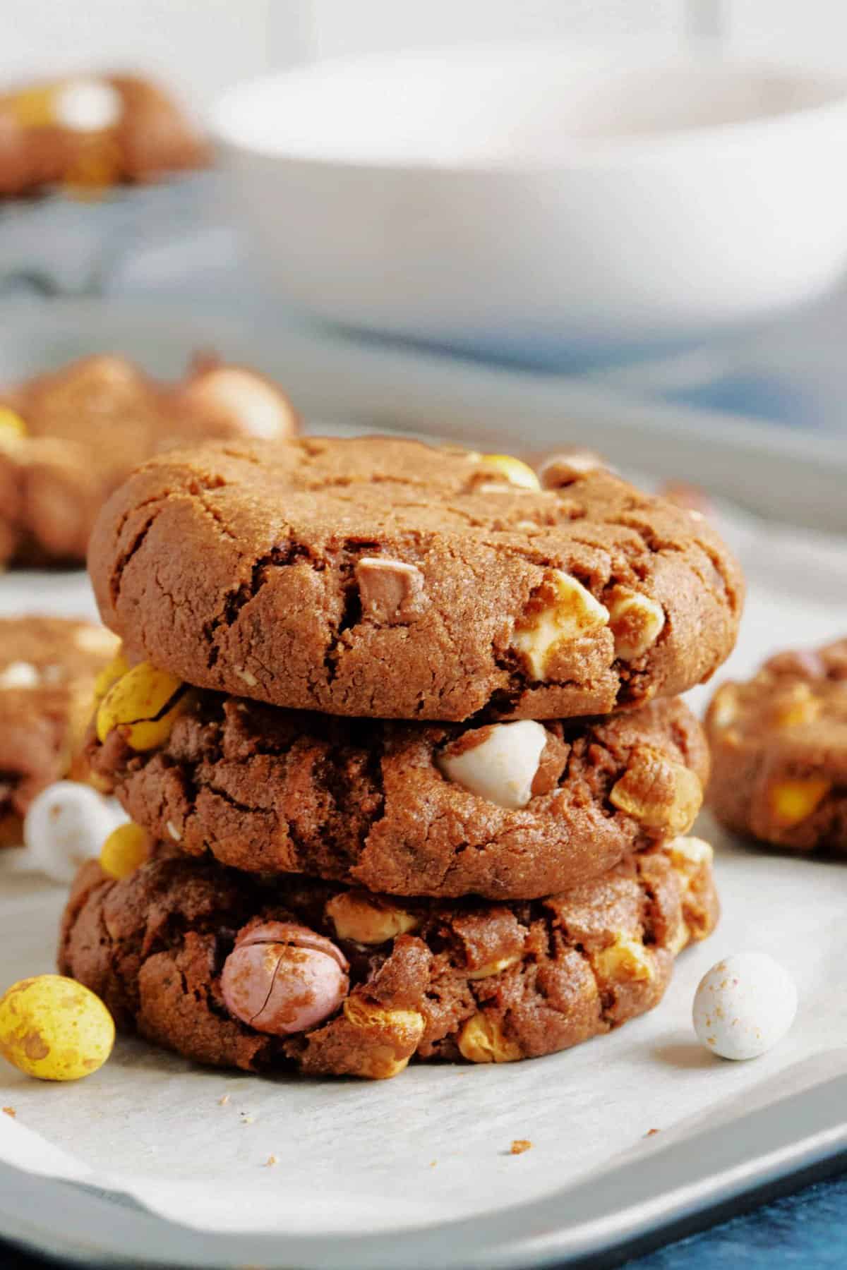 3 chocolate mini egg cookies on a baking sheet.