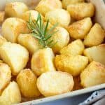 Crispy polenta roast potatoes in a roasting tin.