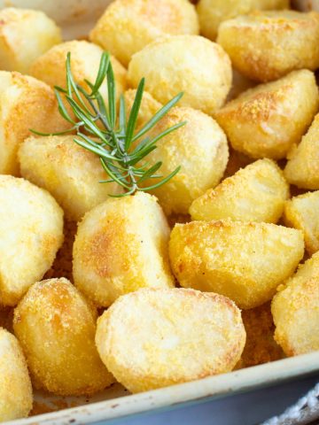 Crispy polenta roast potatoes in a roasting tin.