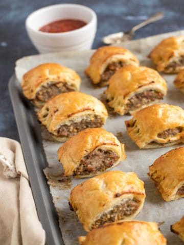 Puff pastry sausage rolls on a tray.