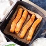 salmon fillets in an air fryer basket.