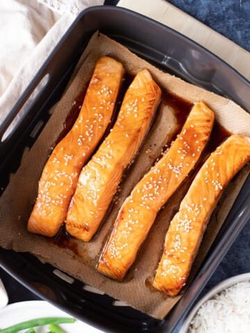 salmon fillets in an air fryer basket.