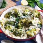 Broccoli and wild garlic risotto with fresh wild garlic leaves in the background.