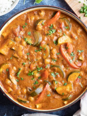 Courgette curry in a red pan.