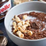 A bowl of Nutella porridge with chopped hazelnuts.