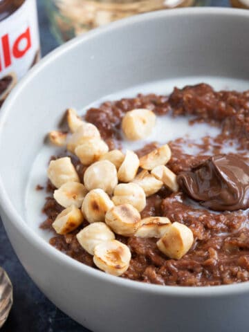 A bowl of Nutella porridge with chopped hazelnuts.