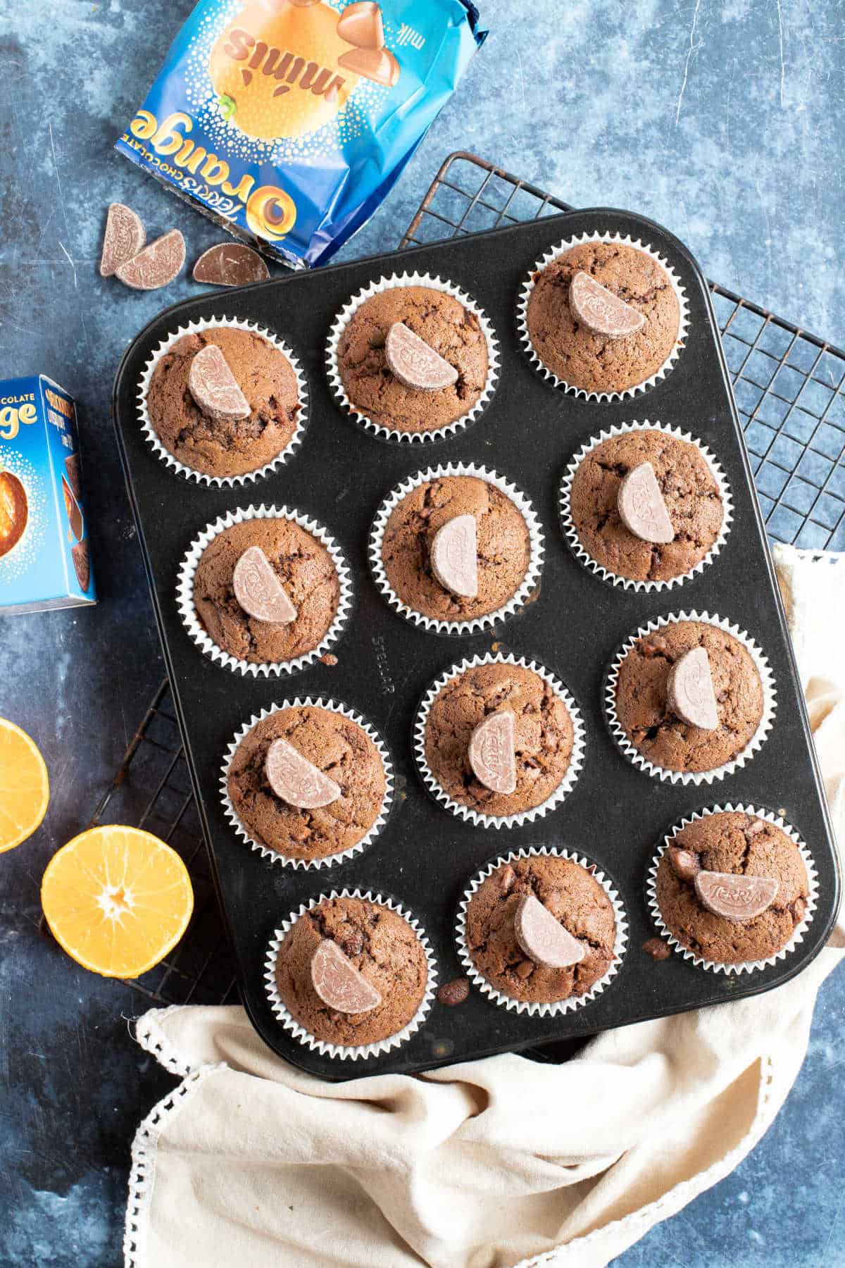 Chocolate orange muffins in a baking tin.