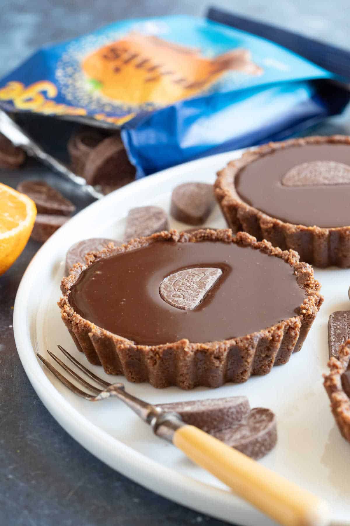 No bake chocolate orange tarts on a serving platter.