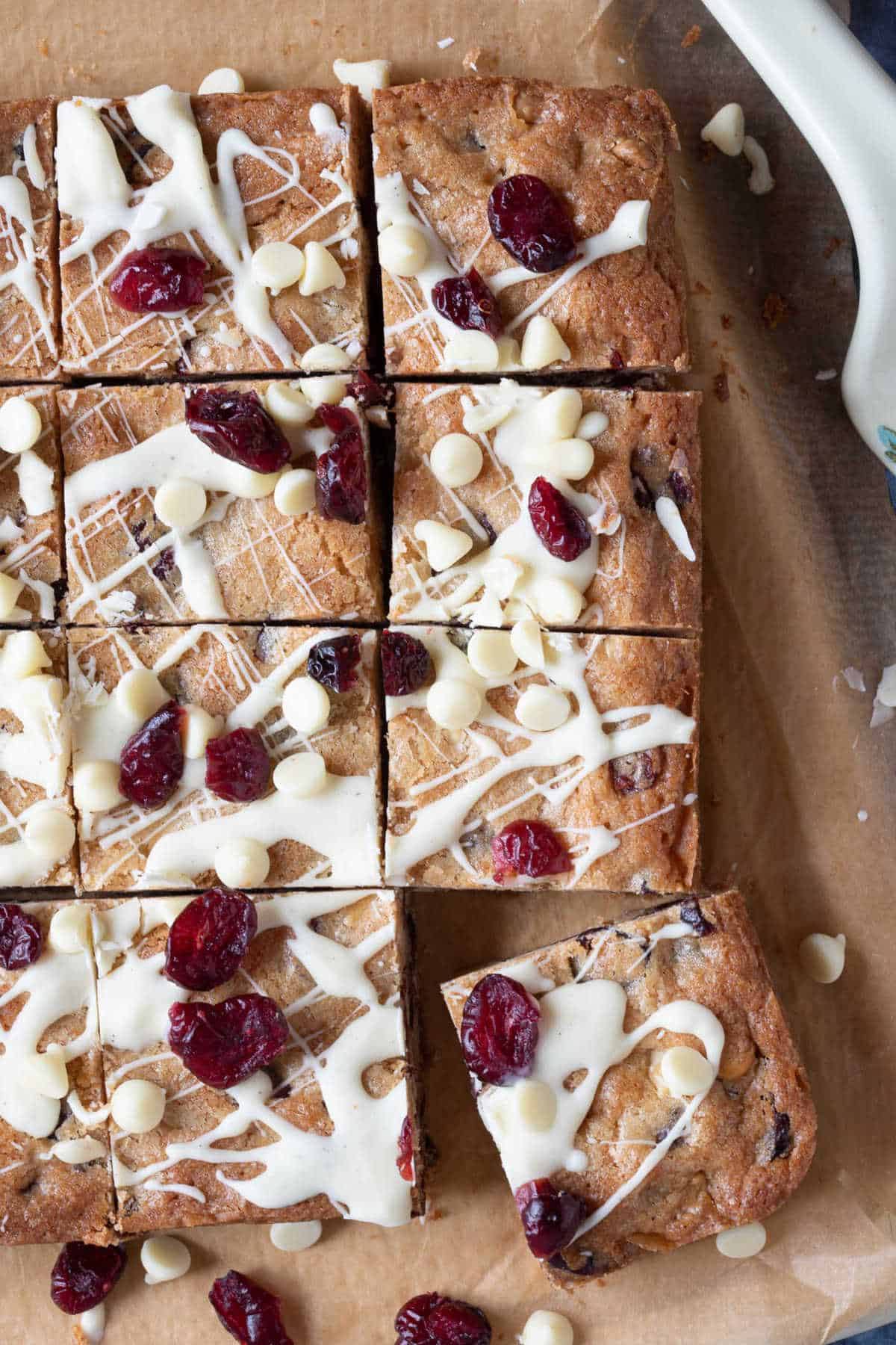 Cranberry white chocolate blondies on a chopping board.