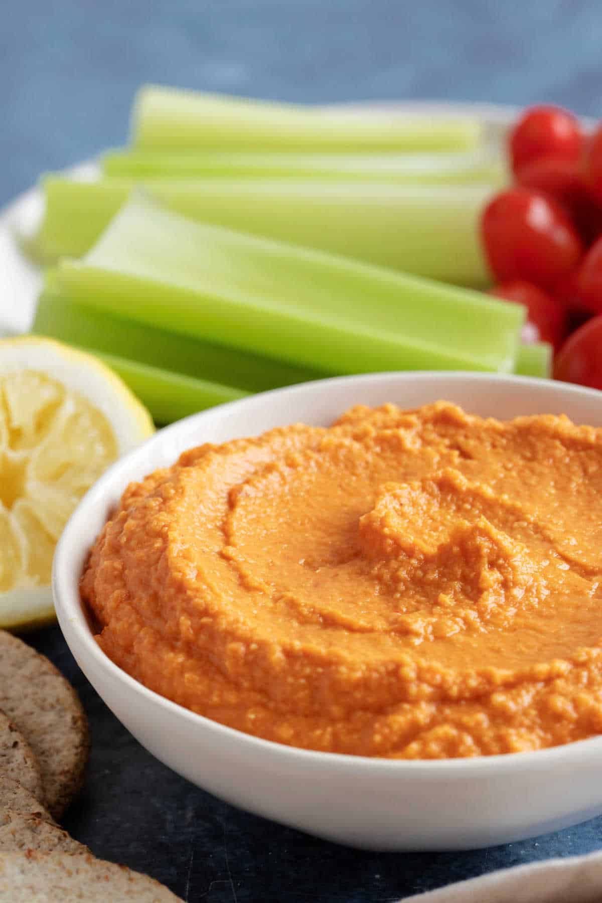 Roasted red pepper hummus in a white bowl.