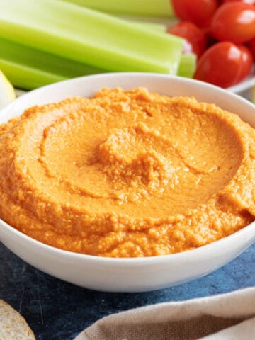 Roasted red pepper hummus with celery sticks.