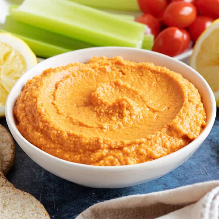 Roasted red pepper hummus with celery sticks.