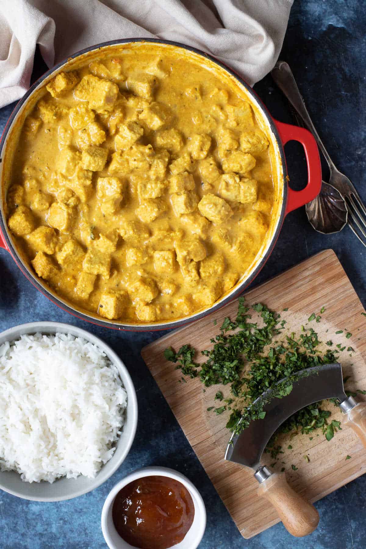 Quorn curry with chopped coriander leaves, rice, and mango chutney.