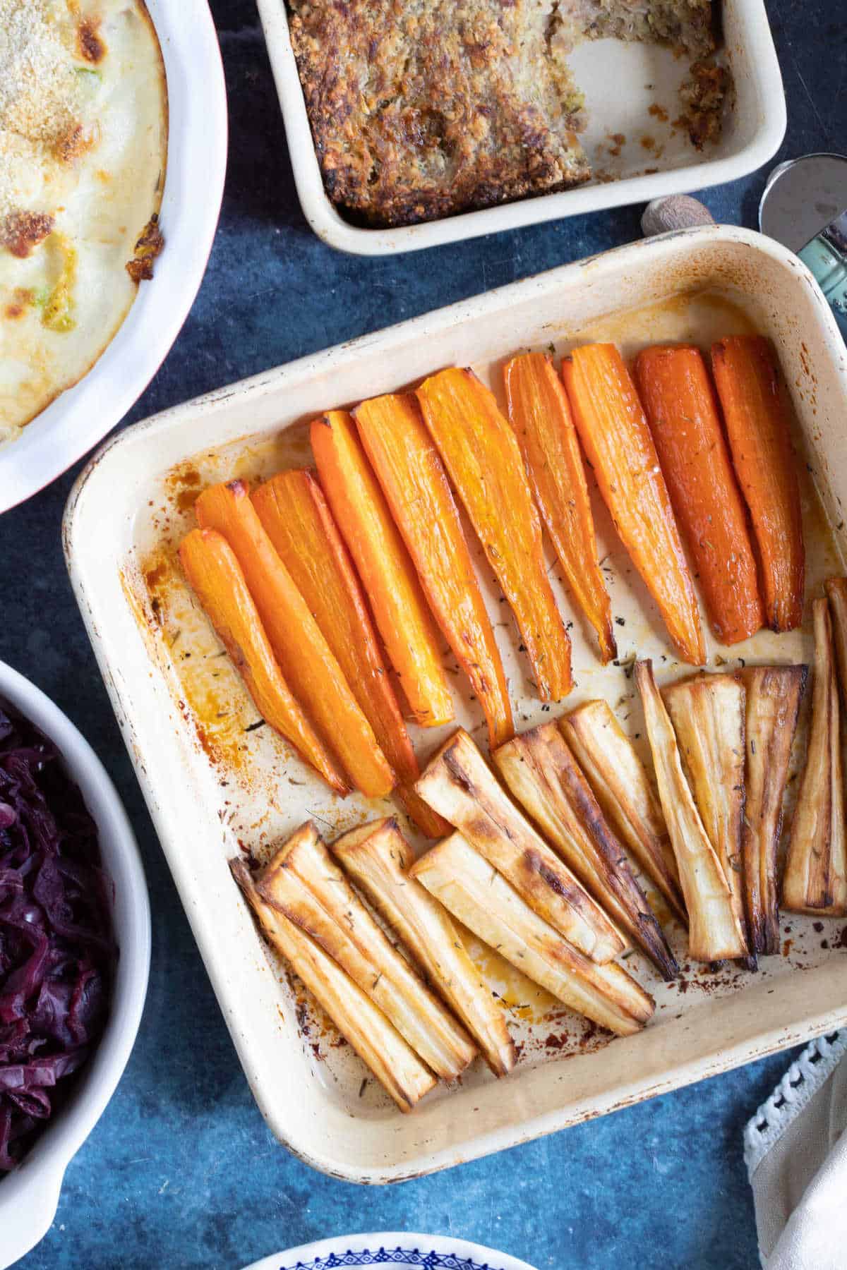 Honey roasted carrots and parsnips in a baking tin.