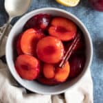 Stewed plums in a bowl with cinnamon.