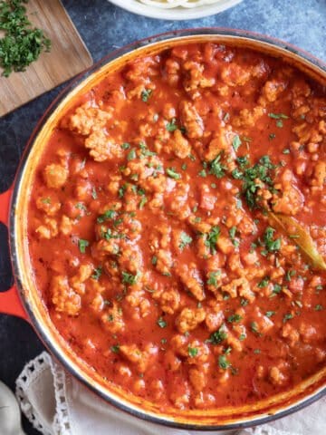 Chicken bolognese garnished with parsley.
