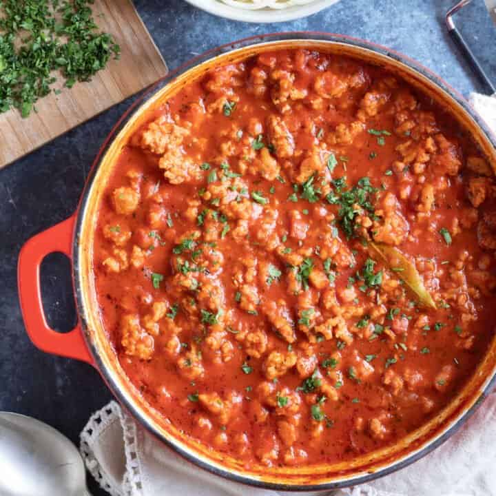 Chicken bolognese garnished with parsley.