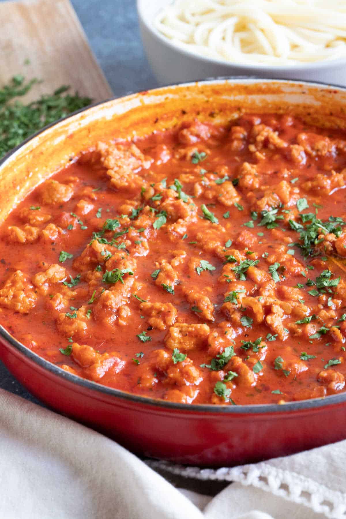 Chicken bolognese in a red pan.
