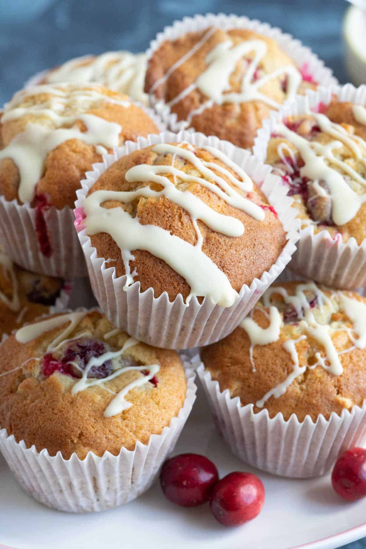 Cranberry white chocolate muffins on a cake stand.