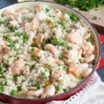 Hot smoked salmon and prawn risotto in a red pan.