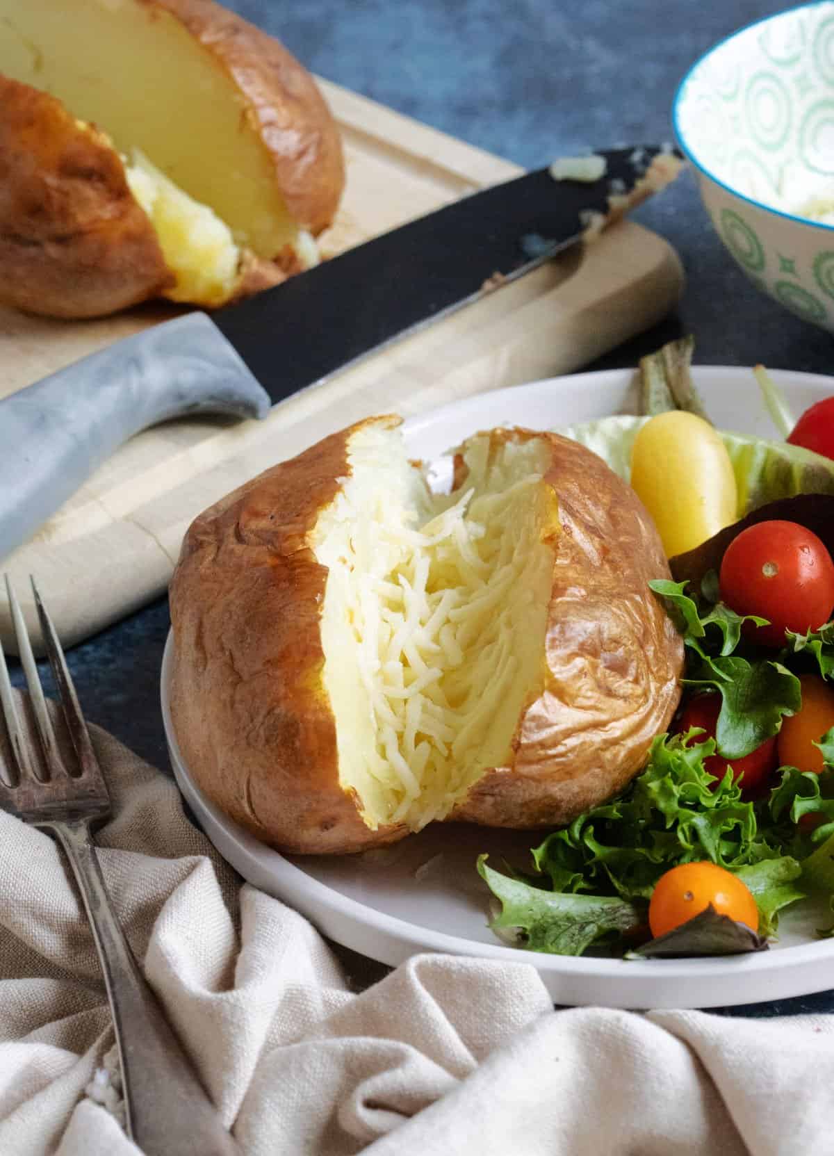 Air fryer baked potatoes served with a side salad.